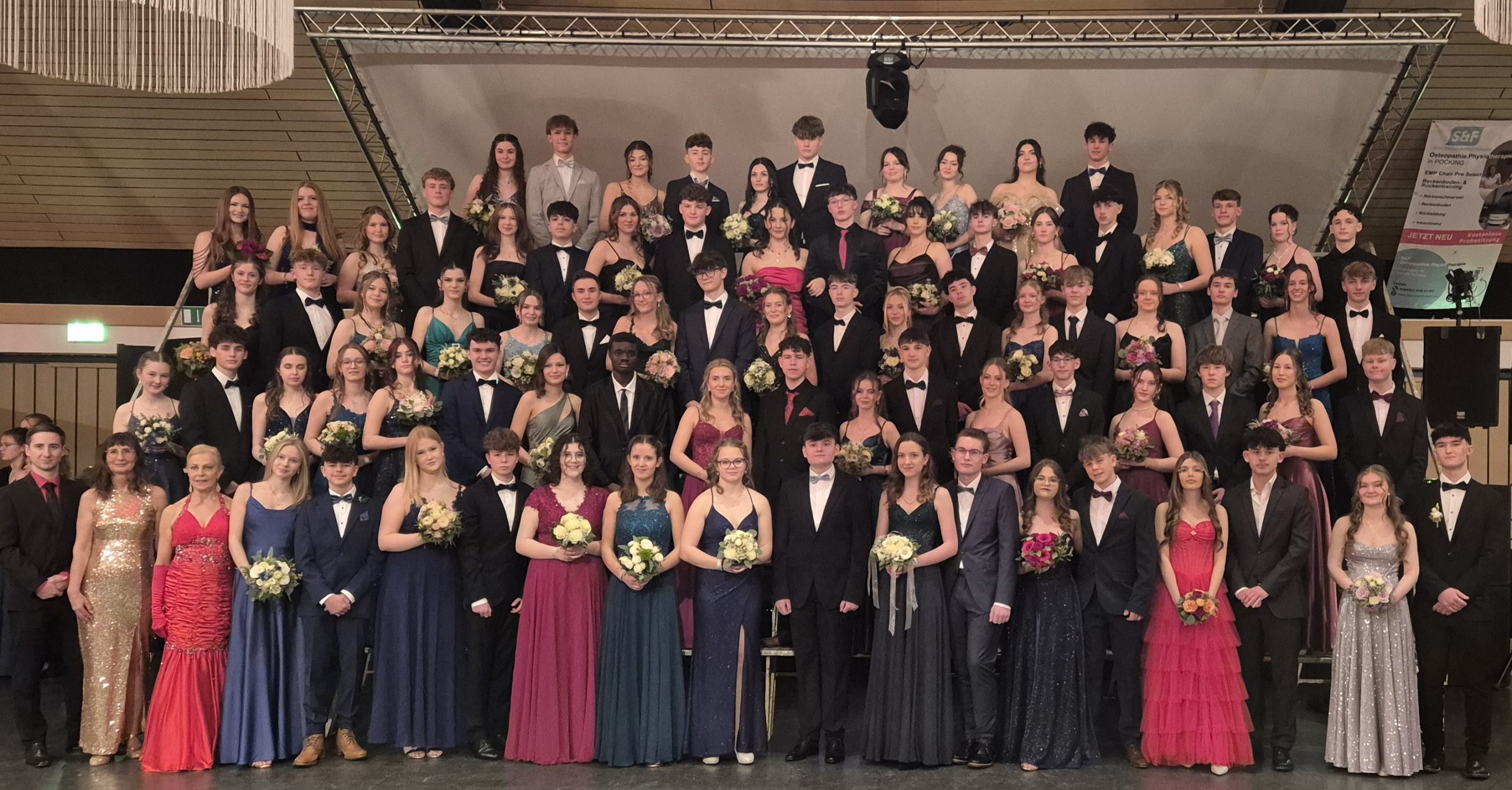 Geschminkt, die Haare gesteckt und gelegt, Kleid und Anzug sitzen perfekt - und hoffentlich drückt kein Schuh: Die Schülerinnen und Schüler der zehnten Klasse des Pockinger Gymnasiums stellen sich zum Erinnerungsfoto mit ihrer Tanzlehrerin Andrea Kraus (1. Reihe, 3.v.l.) auf.